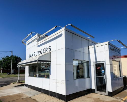 Exterior of a classic American diner with a vintage design in Livonia, Michigan. Clear blue sky emphasizes the nostalgic ambiance.