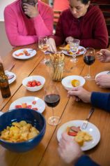 Friends enjoying a casual meal with wine and appetizers at home in Portugal.