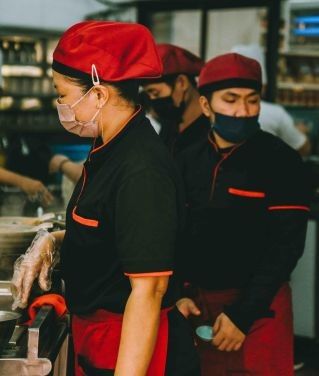Chefs working diligently in a bustling Kuala Lumpur restaurant kitchen.